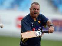 Pakistan's team coach Dav Whatmore helps fielders during the team's net session at Dubai stadium on November 12, 2013